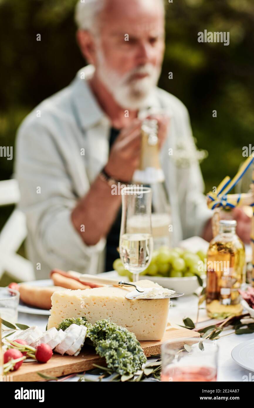 Käse auf Holzbrett, Mann auf Hintergrund Stockfoto