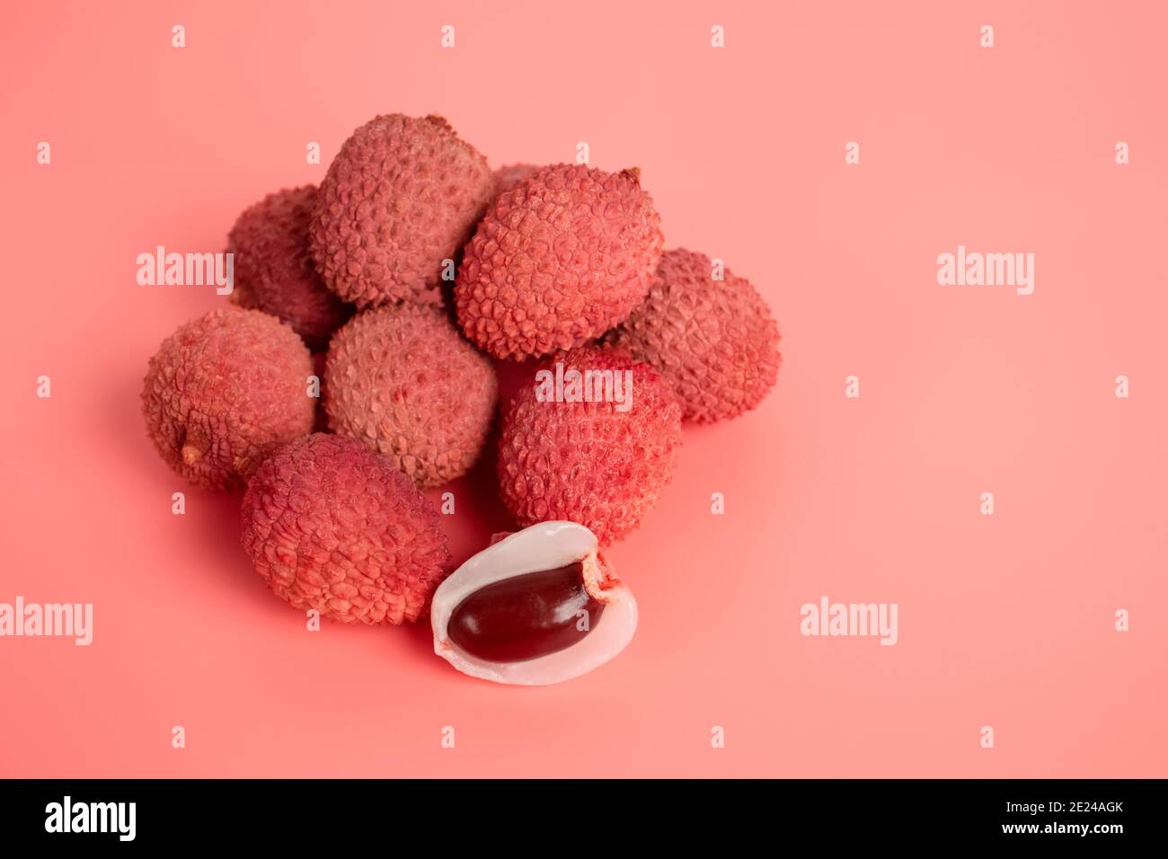 Tropische Früchte - Litschi oder Litschi auf rosa Hintergrund mit Kopierraum. Selektiver Fokus Stockfoto