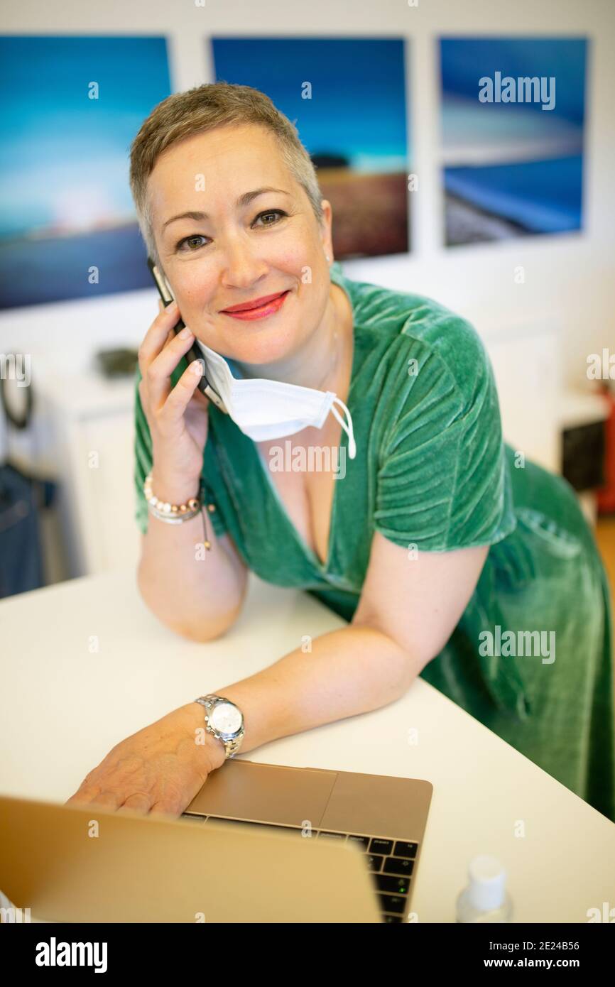 Lächelnde Geschäftsfrau am Telefon, die die Kamera anschaut Stockfoto