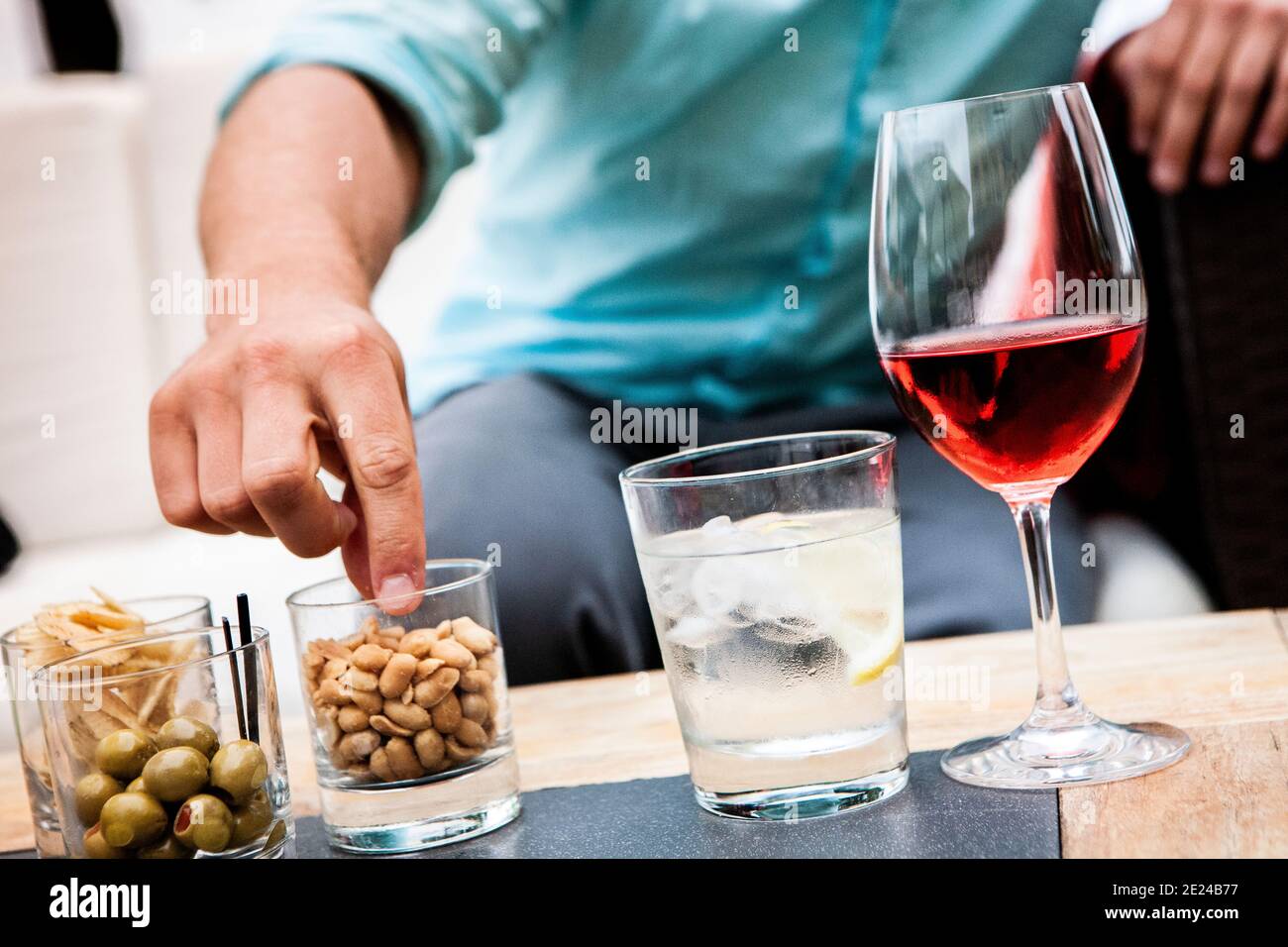 Mans Hand greift nach Smacks auf dem Tisch Stockfoto