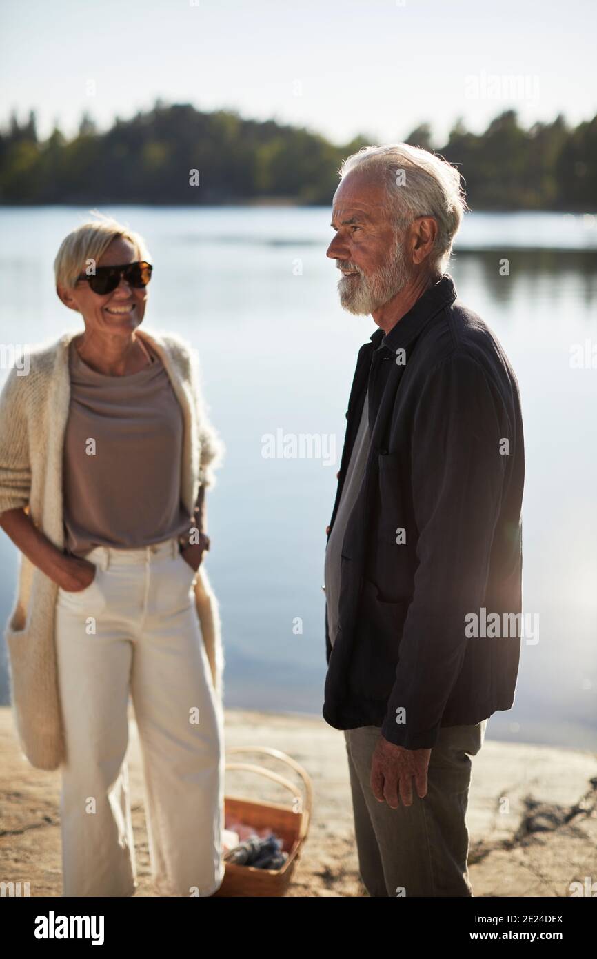 Lächelndes Paar, das am See steht Stockfoto