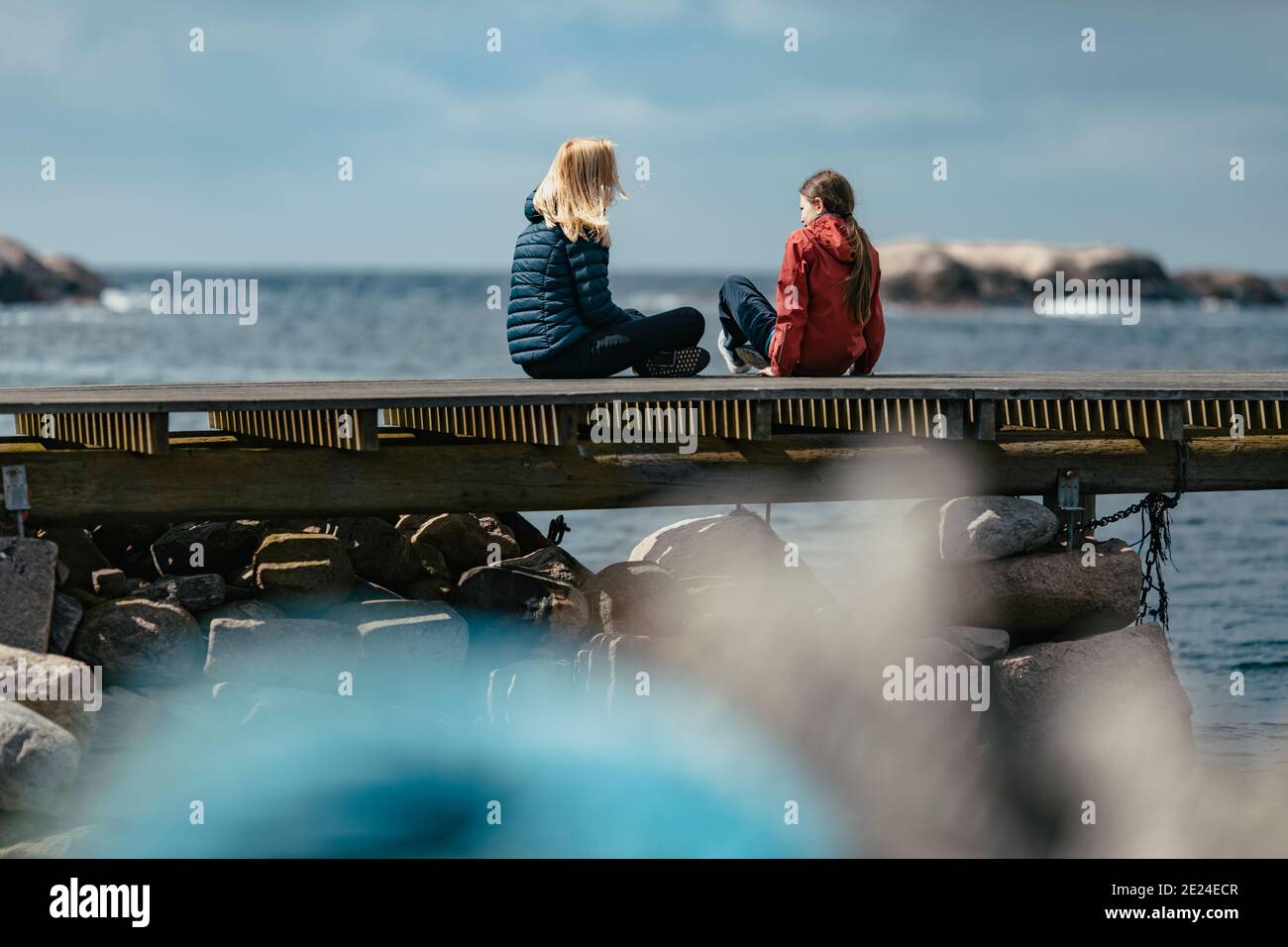 Mutter und Tochter sitzen auf dem Steg Stockfoto