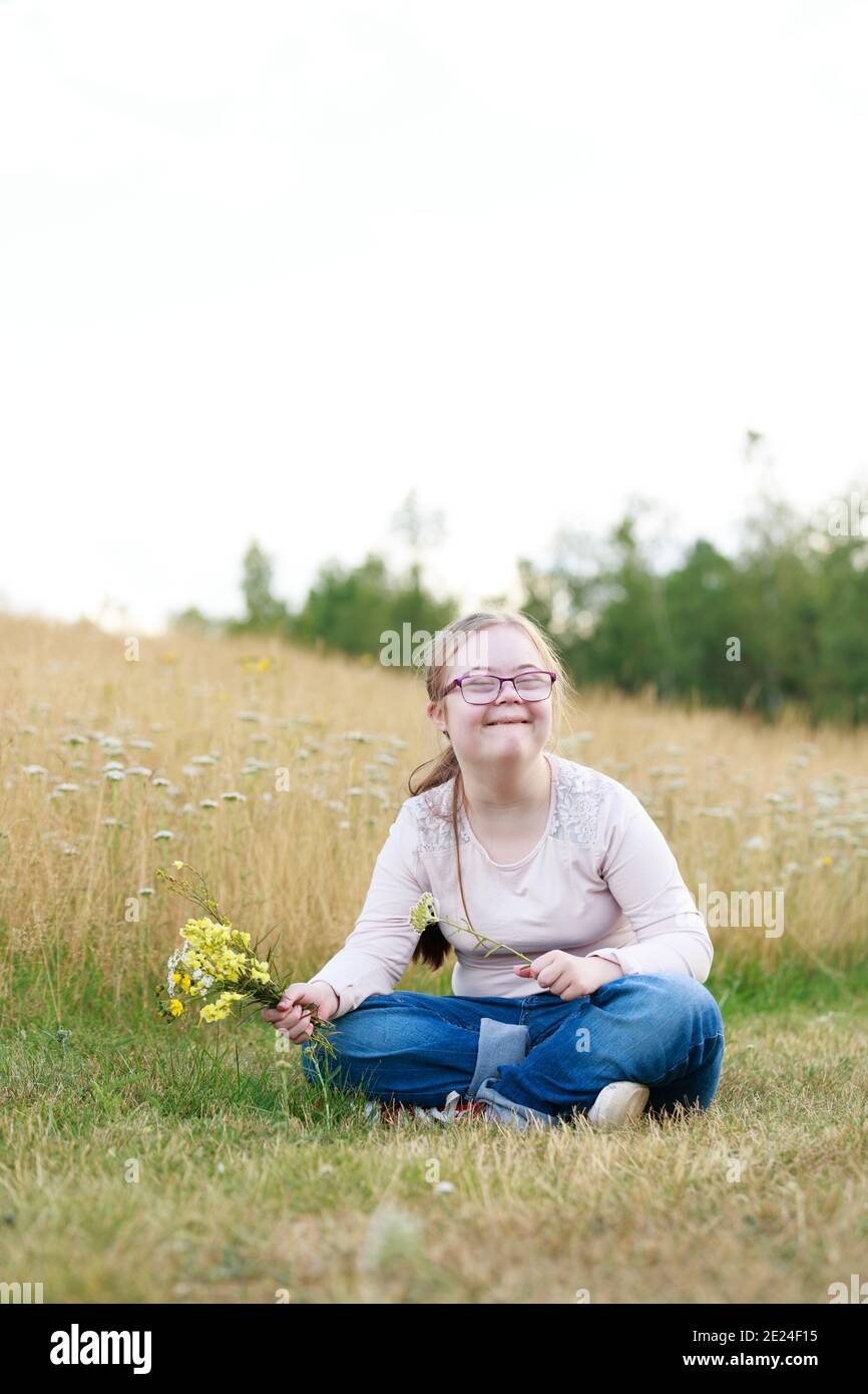 Lächelndes Mädchen auf der Wiese mit Wildblumen Stockfoto