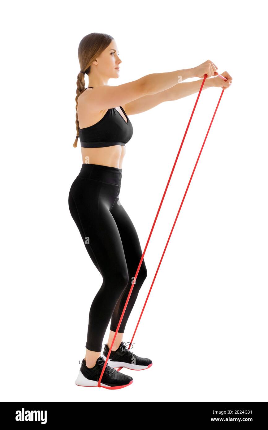 Frau Athletentraining mit einem Powerband tun einen frontalen Rise Übung, um ihre Muskeln isoliert auf weiß in zu stärken Ein Gesundheits- und Fitnesskonzept Stockfoto