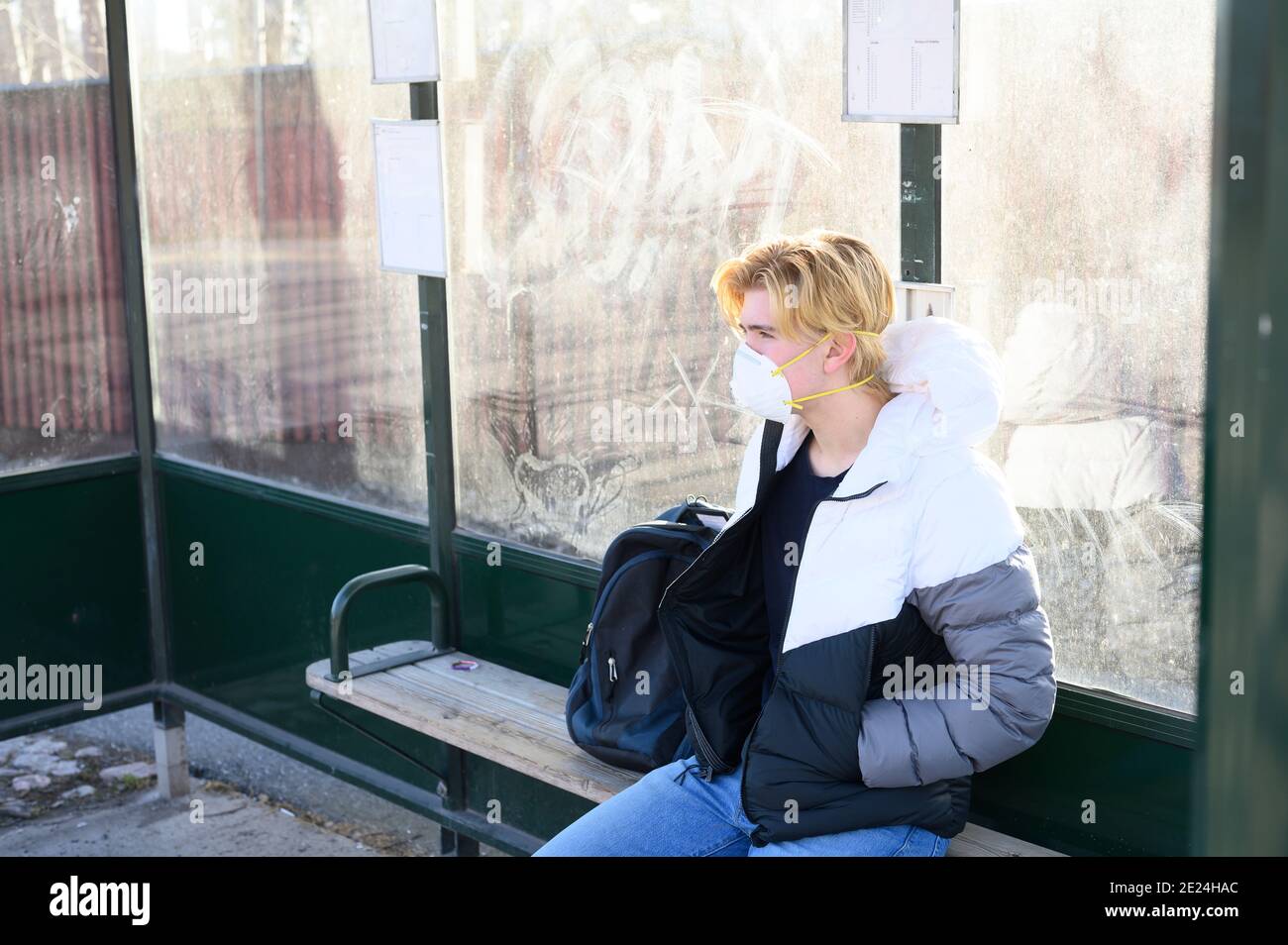 Teenager wartet an der Bushaltestelle Stockfoto