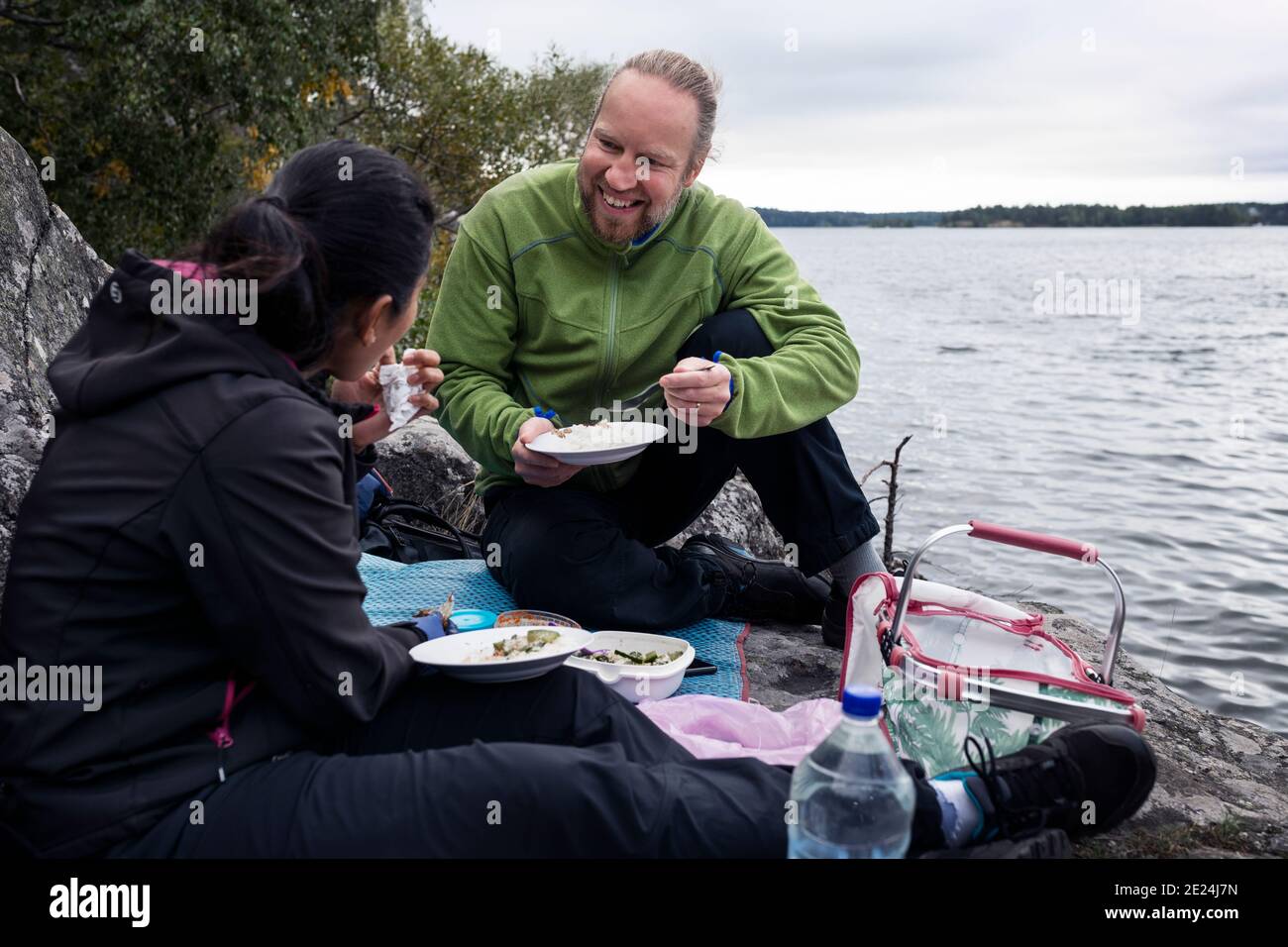 Pärchen, die am See picknicken Stockfoto