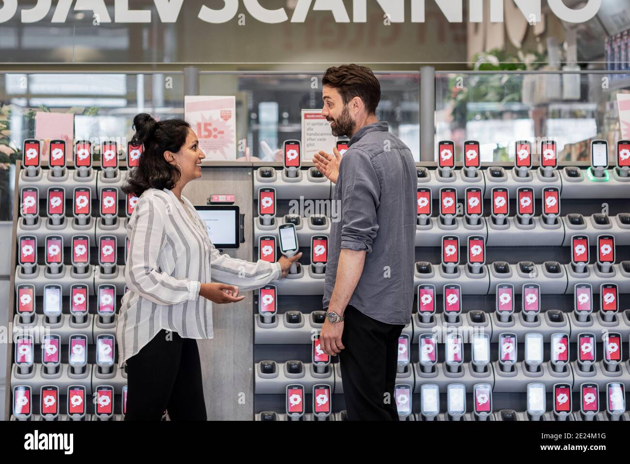 Paar vor Barcode-Lesern im Supermarkt Stockfoto