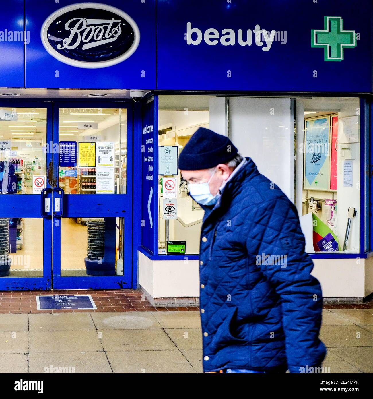 London UK, Januar 07 2021, Senior man geht an EINEM Stiefel Apotheke Laden mit EINEM schützenden Gesicht Abdeckung oder Maske Stockfoto