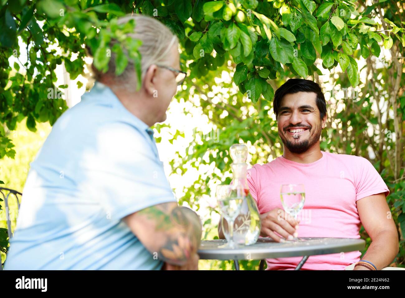 Lächelnde Männer, die im Garten reden Stockfoto