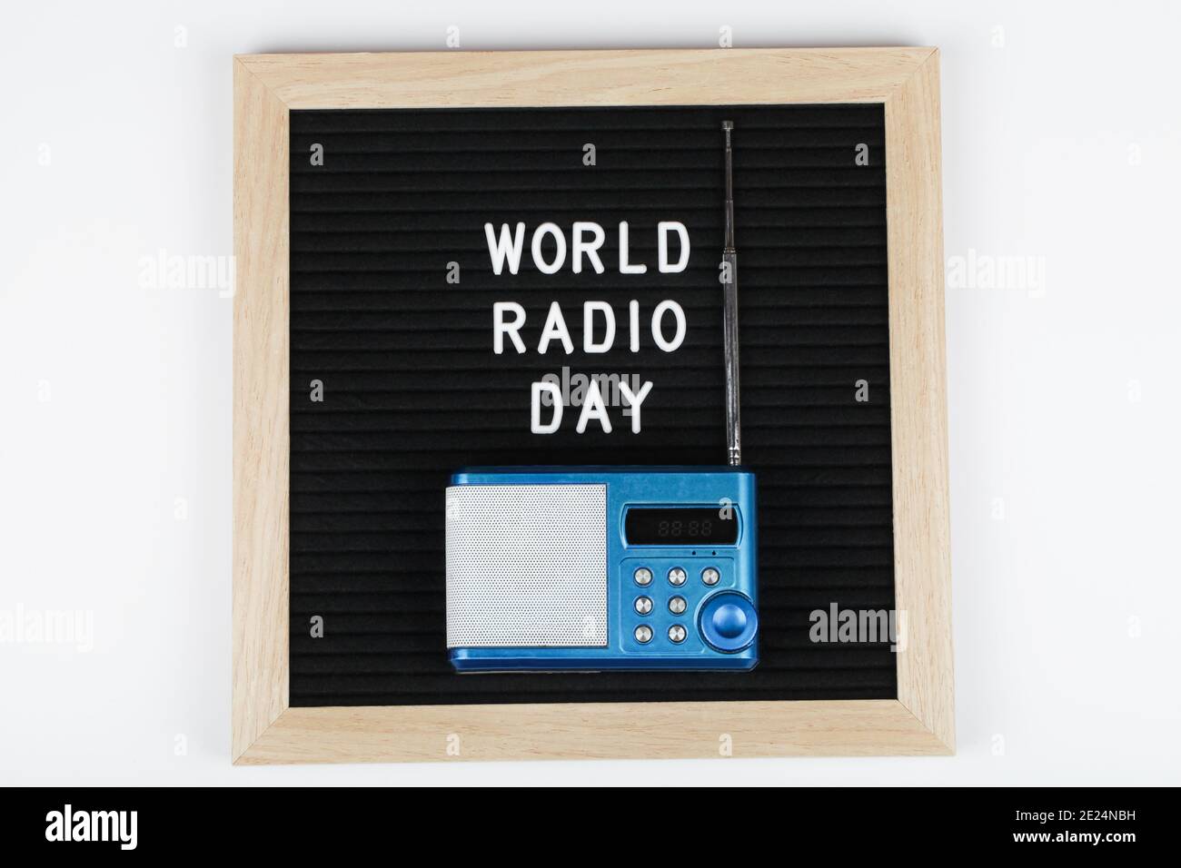 Schwarzes Briefbrett mit Text Welt Radio Tag mit blauem Radio auf weißem Hintergrund. Draufsicht. Flach legen minimalen Hintergrund. Stockfoto