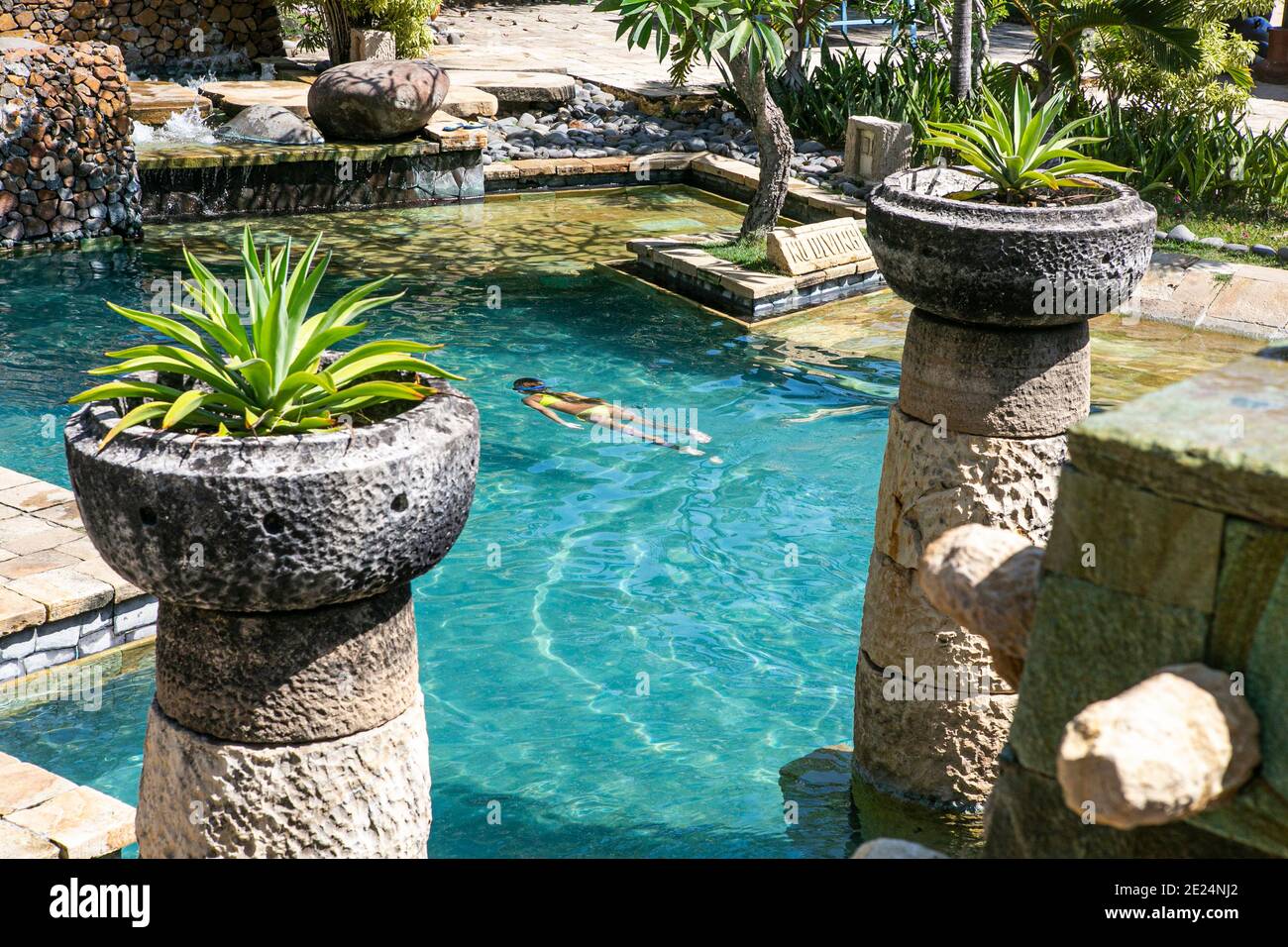 Schwimmdame in einem Resort Pool in Bali... Stockfoto