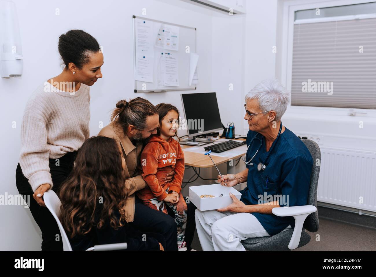 Eltern mit Tochter im Arztbüro Stockfoto