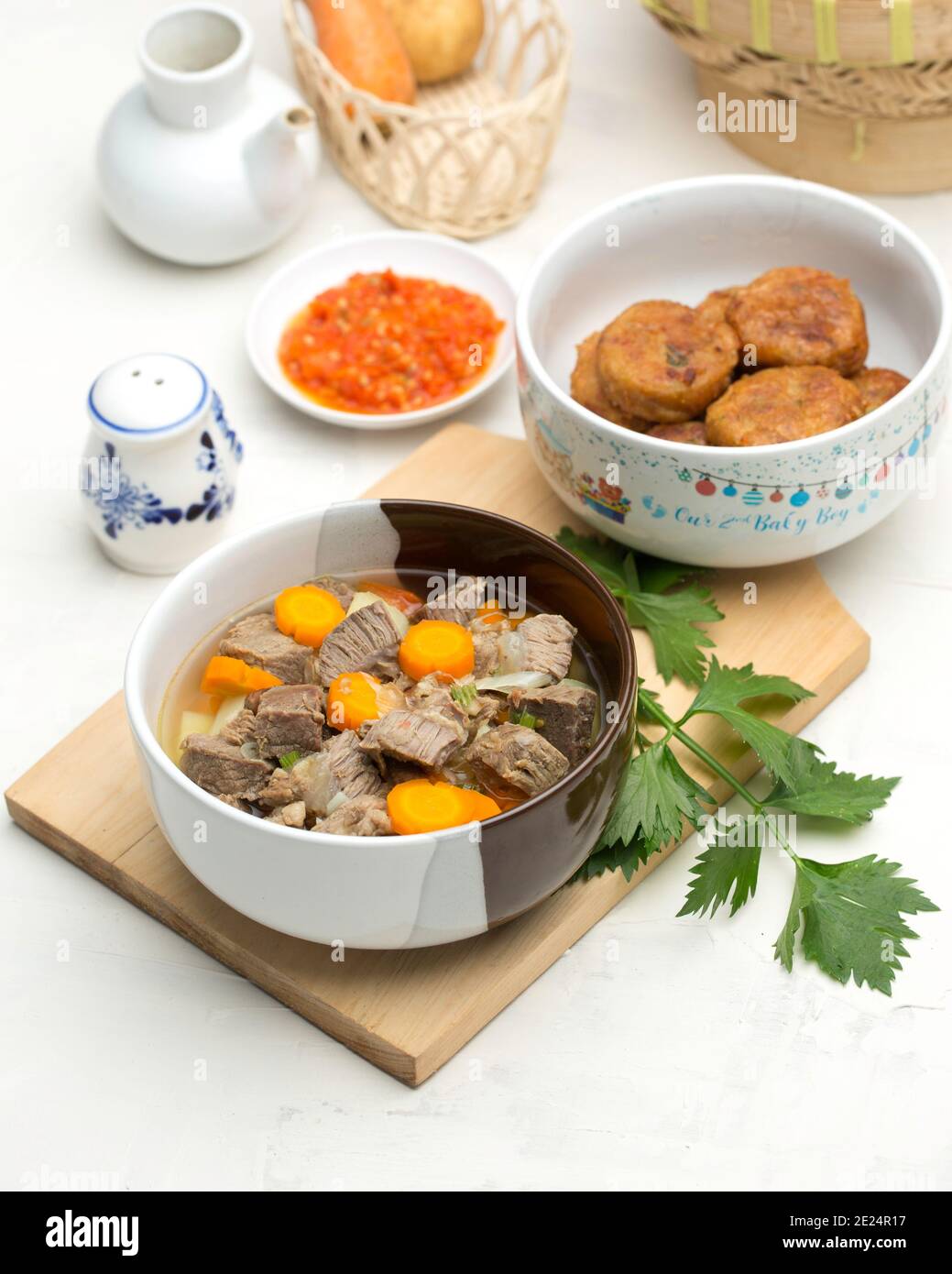 Rind- und Karottensuppe mit gebratenen Kartoffelkuchen und Chili Soße Stockfoto