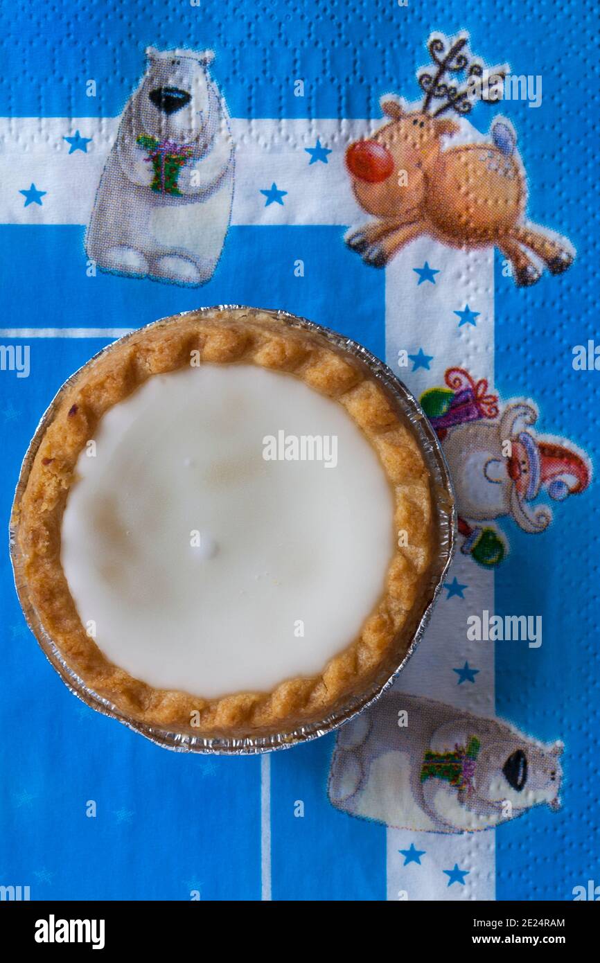 iced topped Mince Pie von Sainsburys auf festlicher Serviette mit Weihnachtsserviette - Konditoreien gefüllt mit Hackfleisch, gekrönt mit weicher weißer Fondant-Vereisung Stockfoto