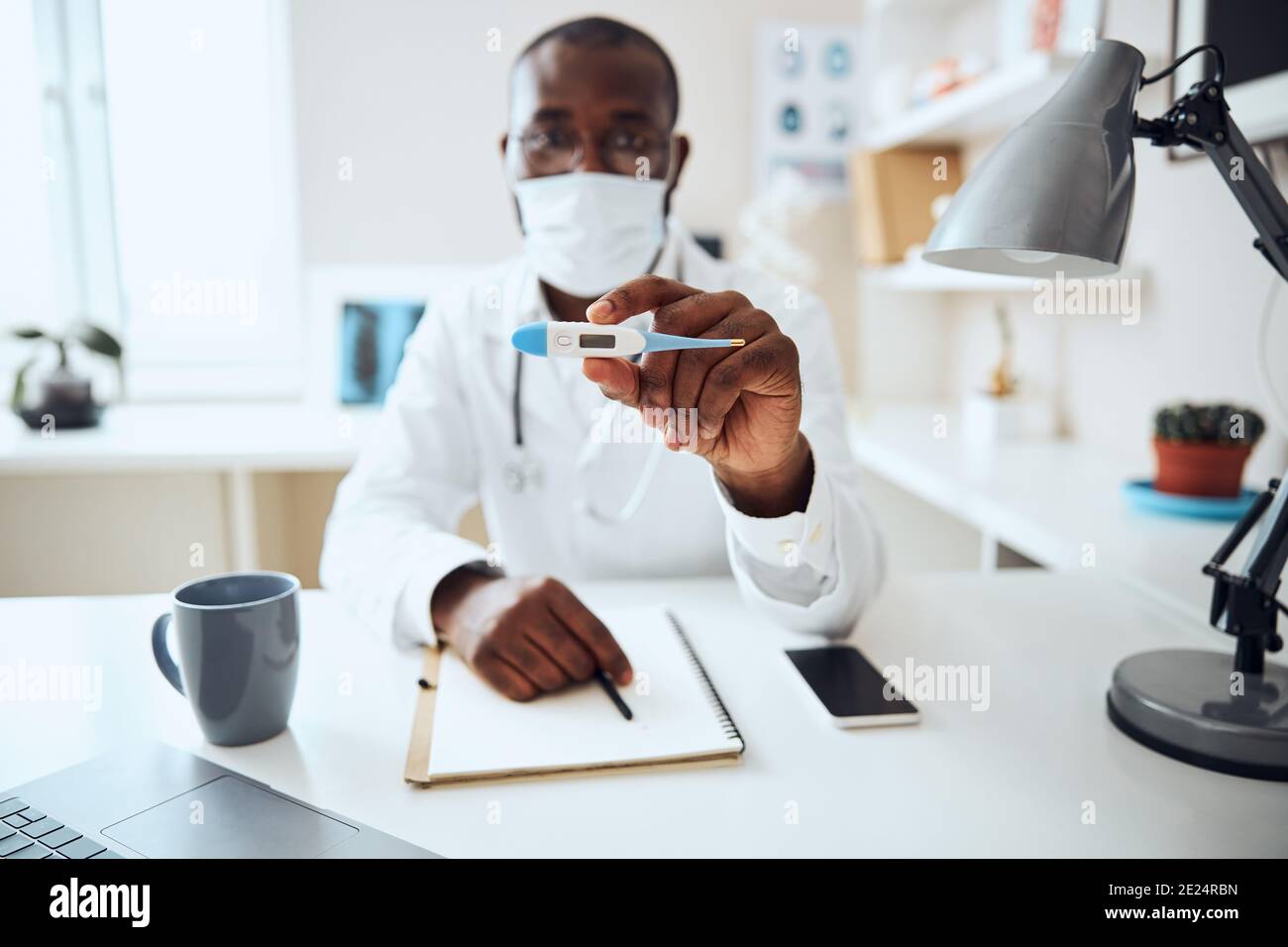 Erfahrene Sanitäter zeigt ein digitales Thermometer Stockfoto