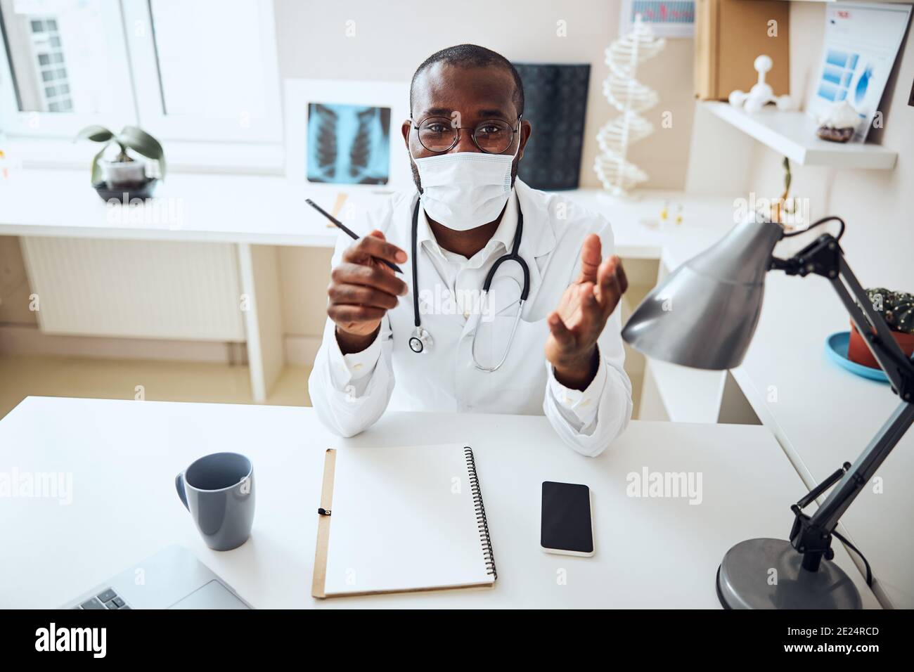 Medizinische Fachkraft in einer Gesichtsmaske Begrüßung des Kunden Stockfoto