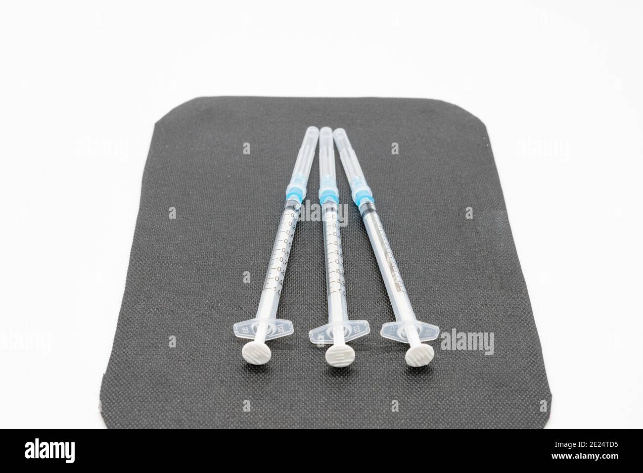 Medizinische Spritzen und Nadeln für die Injektion von Hypodermiken auf einer Arbeitsplatte aus Marmor. Spritze und Nadel sind verschlossen. Stockfoto