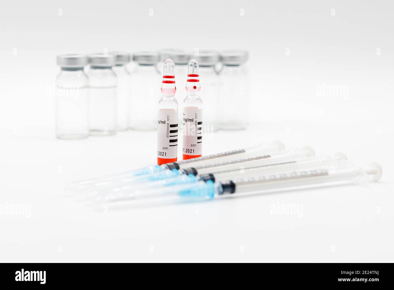 Medizinische Spritzen und Nadeln für die Injektion der Unterhaut die Spritzen und Nadeln sind verschlossen. Das rote Fläschchen ist der Schwerpunkt. Stockfoto