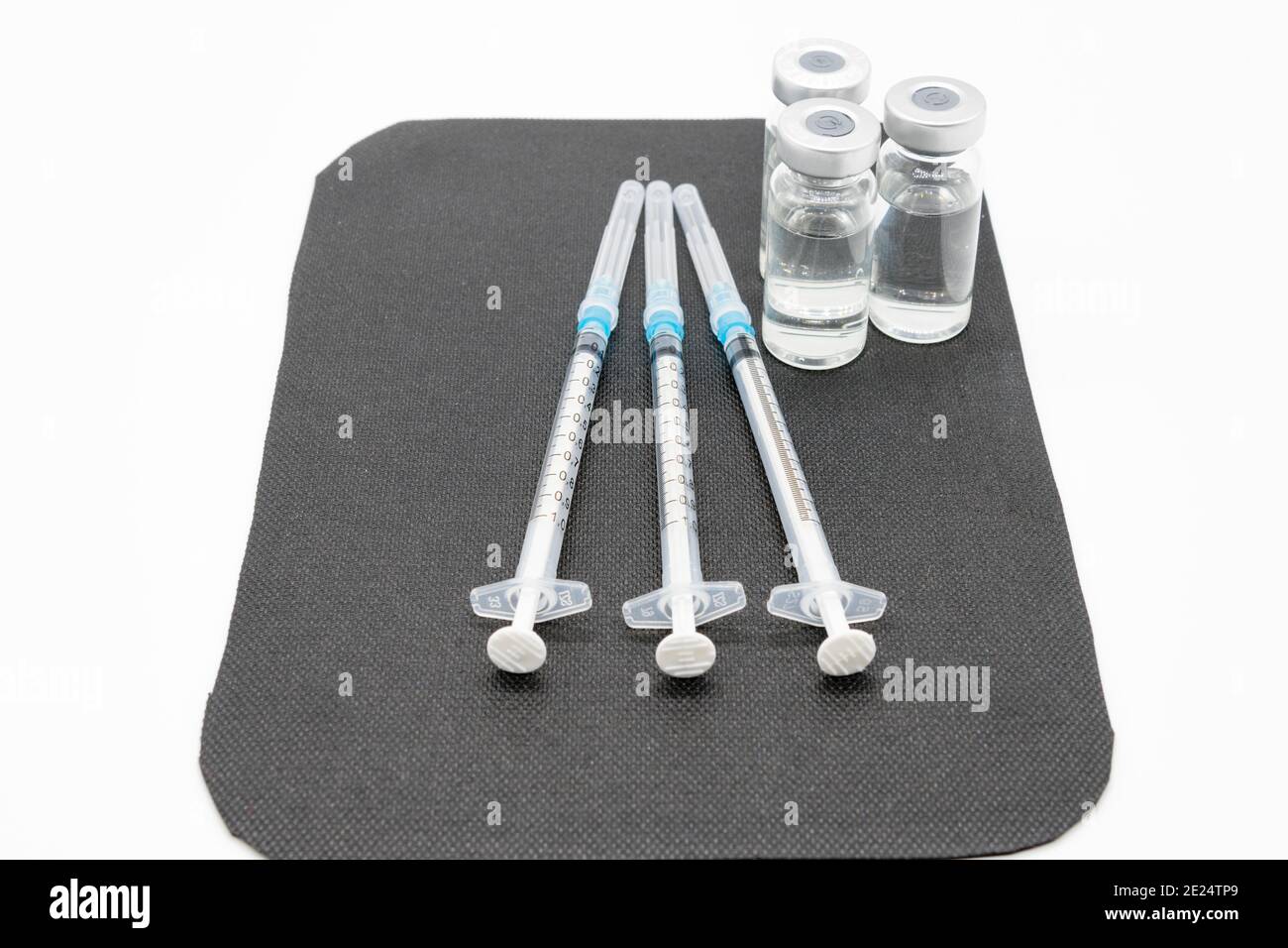 Medizinische Spritzen und Nadeln für die Injektion von Hypodermiken auf einer Arbeitsplatte aus Marmor. Spritze und Nadel sind verschlossen. Stockfoto
