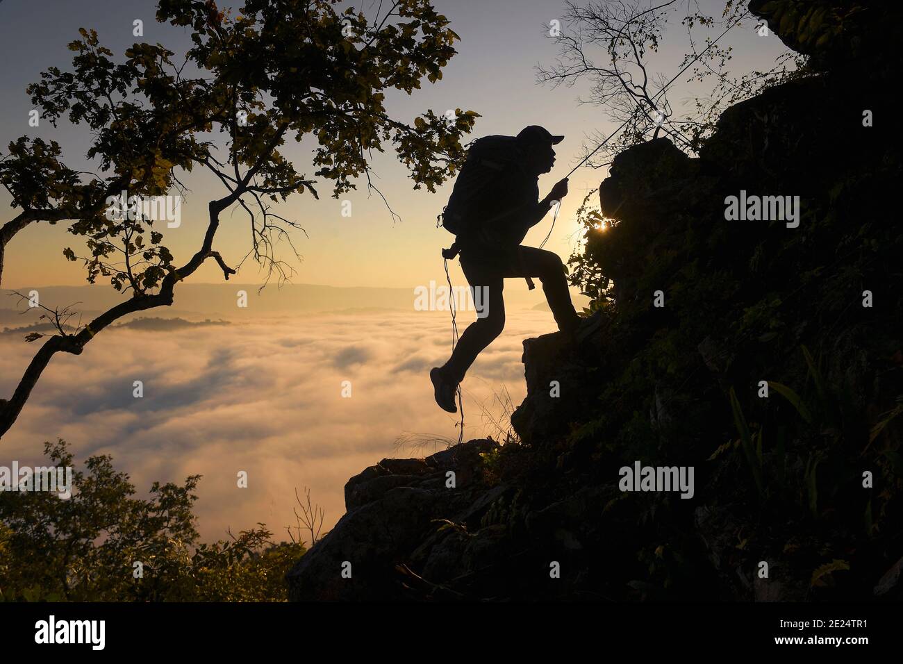 Silhouette eines Mannes Felsen klettern über Wolke Teppich, Thailand Stockfoto