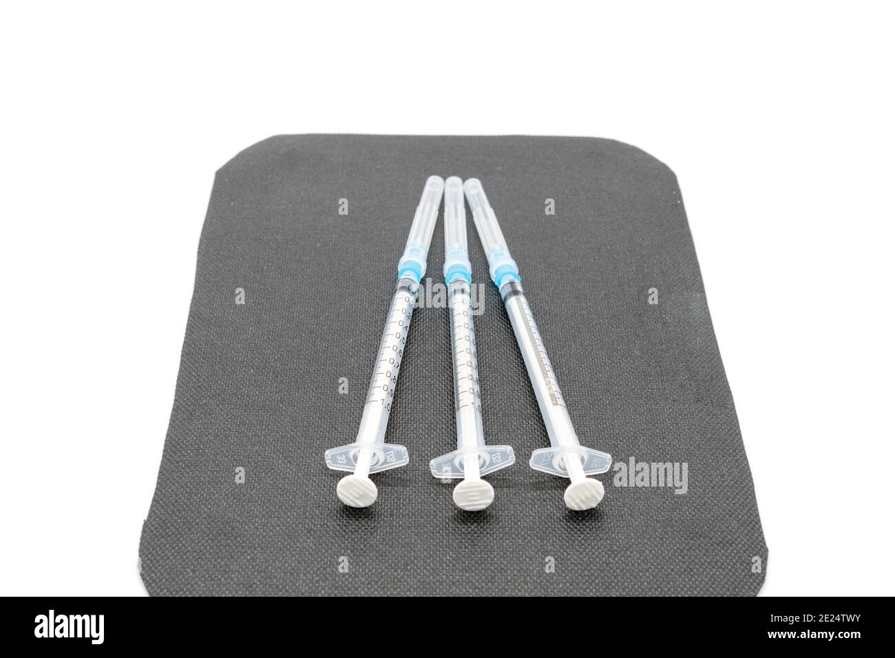 Medizinische Spritzen und Nadeln für die Injektion von Hypodermiken auf einer Arbeitsplatte aus Marmor. Spritze und Nadel sind verschlossen. Stockfoto