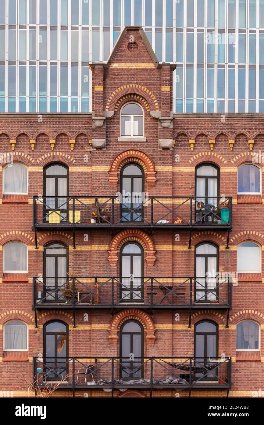 Altes holländisches Lagerhaus, das für die Unterbringung in der Stadt verwendet wurde Rotterdam mit einem Wolkenkratzer im Hintergrund Stockfoto