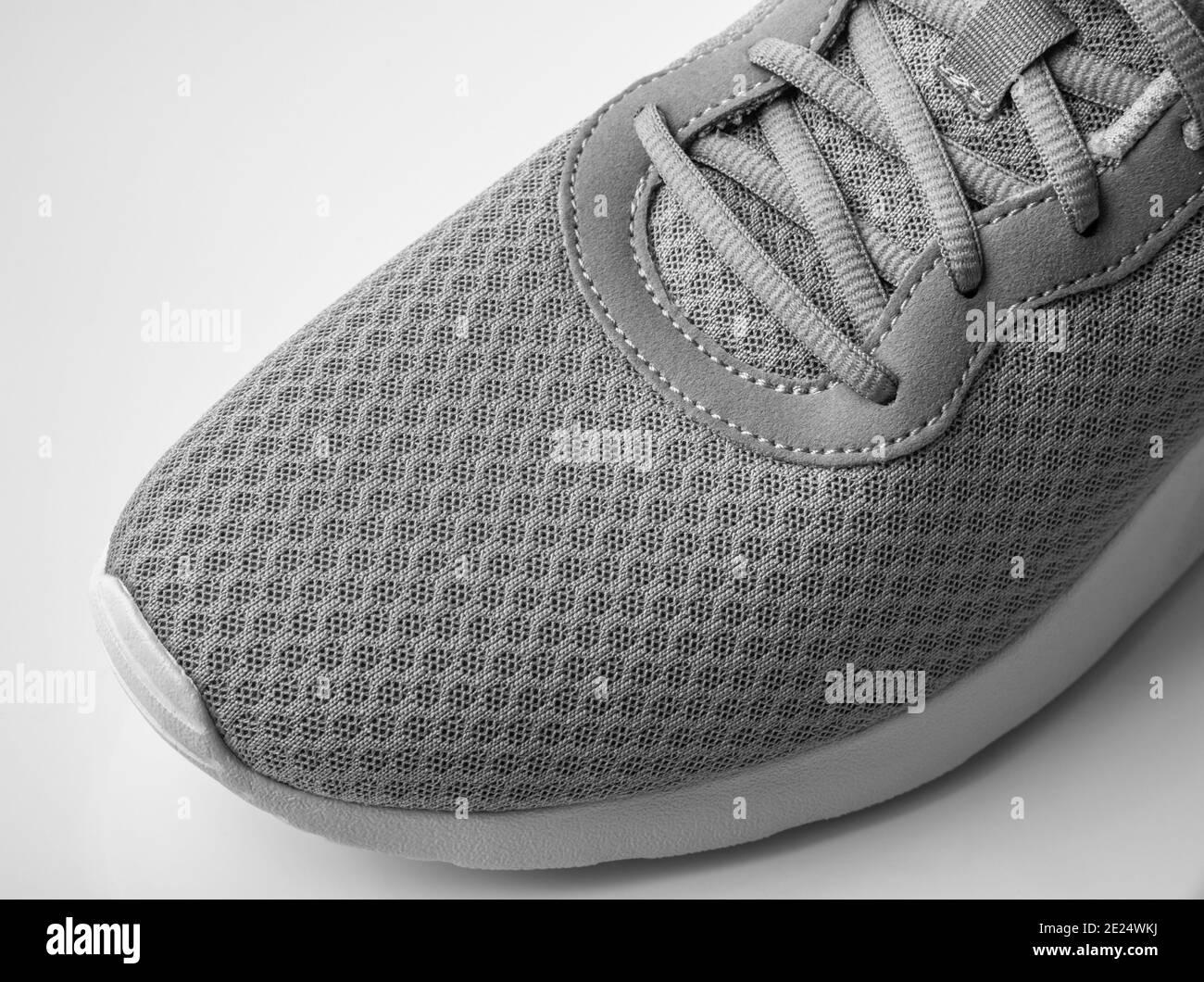 Ein grauer Turnschuh aus Textil auf weißem Hintergrund Stockfoto