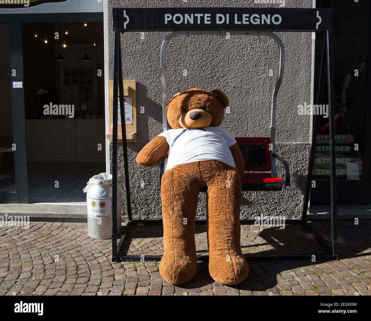PONTE DI LEGNO, ITALIEN, 9. SEPTEMBER 2020 - EIN Teddybär auf einem Schaukelstuhl vor einem Geschäft im Dorf Ponte di Legno, Provinz Brescia, Italien. Stockfoto