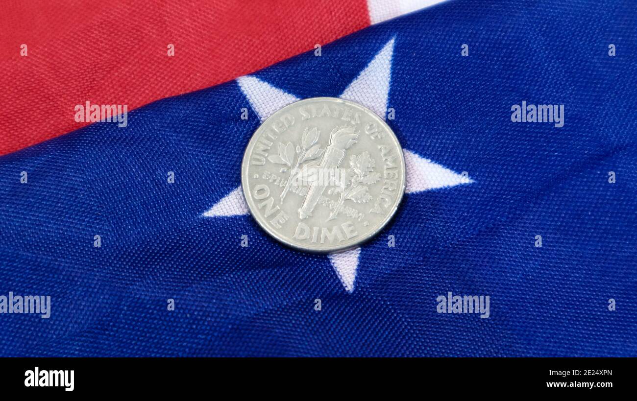 Auf der amerikanischen Flagge liegt eine 1-Cent-Dollar-Münze. Die Währung ist ein Cent über der Flagge der Vereinigten Staaten Stockfoto