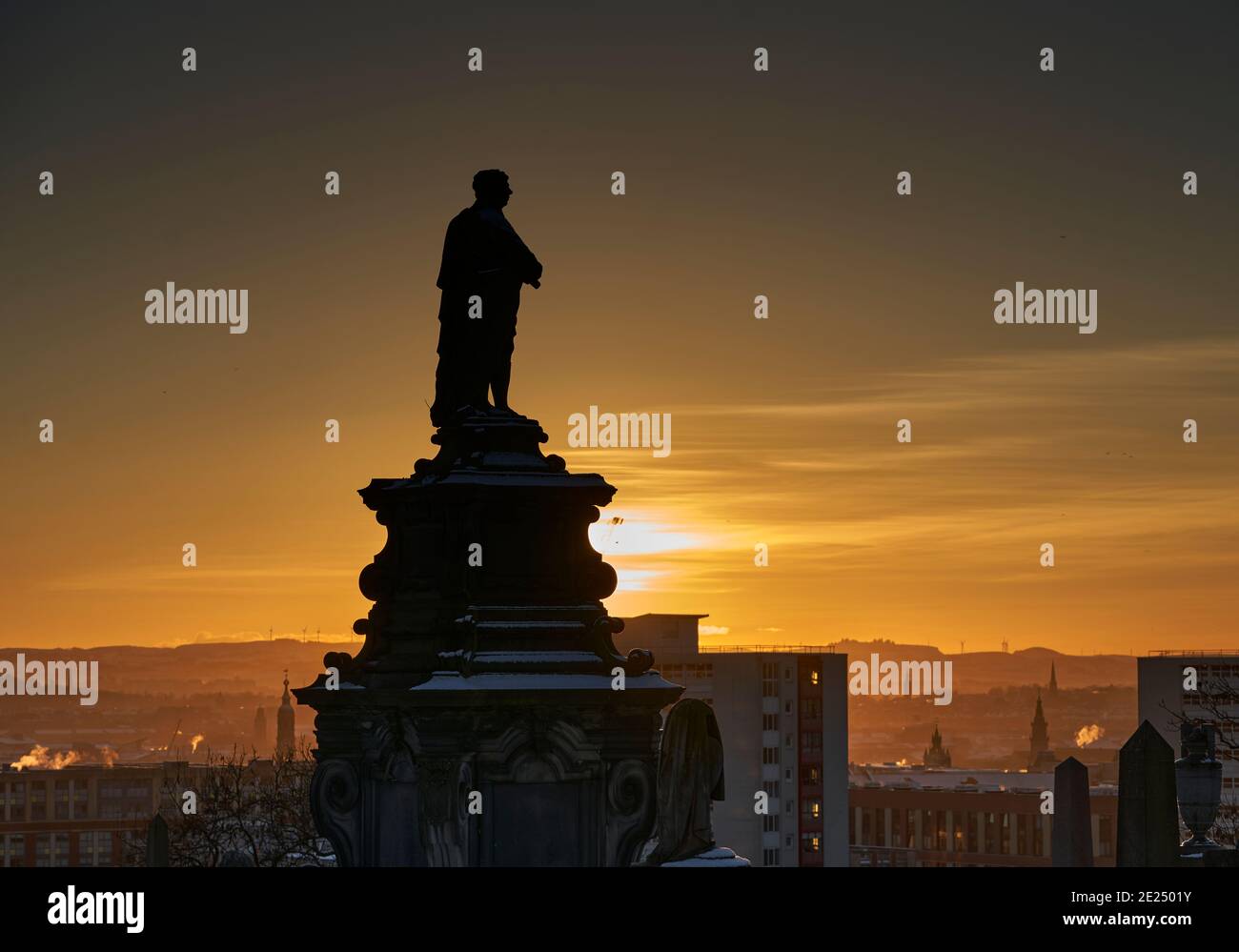 Atemberaubender Sonnenuntergang über der Glasgow Necropolis an einem verschneiten Winterabend, eingerahmt vom Monument für William McGavin. Stockfoto