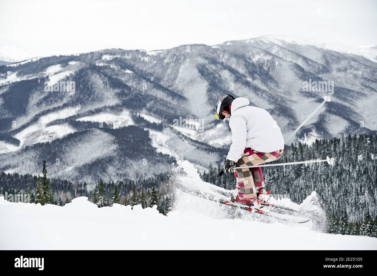 Winter Arten von Sport-Konzept. Skifahrer tragen Wintersport-Kostüm und Skiausrüstung tun Sprung Trick in der Wintersaison. Animation im Skigebiet in den Bergen, Rückansicht, Kopierraum Stockfoto