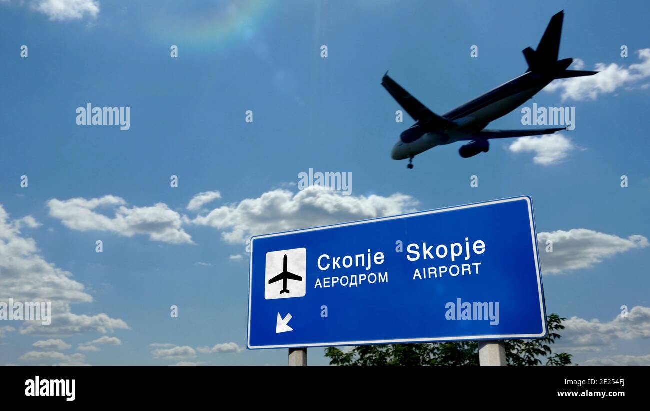 Flugzeug Silhouette Landung in Skopje Nord Mazedonien. City Ankunft mit internationalen Flughafen Richtung Schild und blauen Himmel im Hintergrund. Reisen, Stockfoto