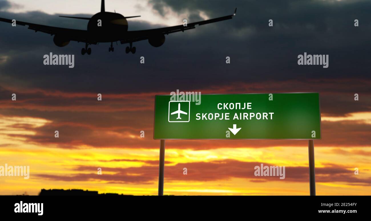 Flugzeug Silhouette Landung in Skopje Nord Mazedonien. City Ankunft mit Flughafen Richtung Schild und Sonnenuntergang im Hintergrund. Reise und Transport Stockfoto