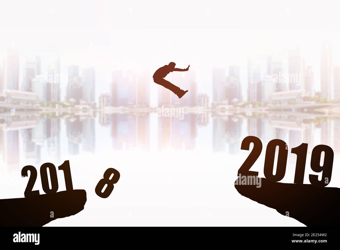 Silhouette des jungen Mannes Springen zwischen 2018 und 2019 Jahren mit schönen Wolkenkratzern Hintergrund, Konzepte des Nachrichtenjahres und Geschäftsziel. Stockfoto
