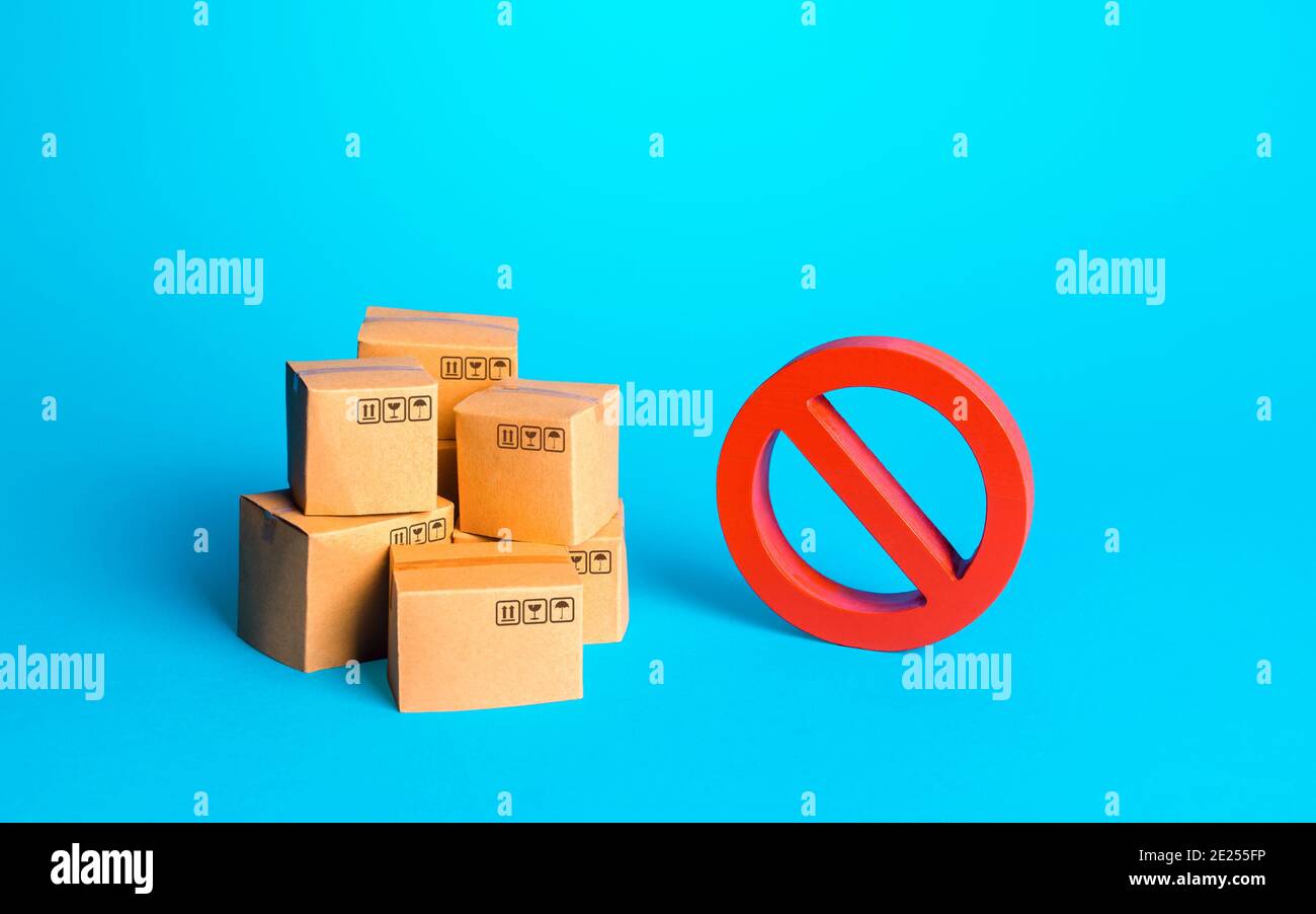 Kartons von Waren und ein rotes Verbotszeichen NR. Schutz der nationalen Hersteller. Bürokratische und wirtschaftliche Einschränkungen für Import-Export oper Stockfoto