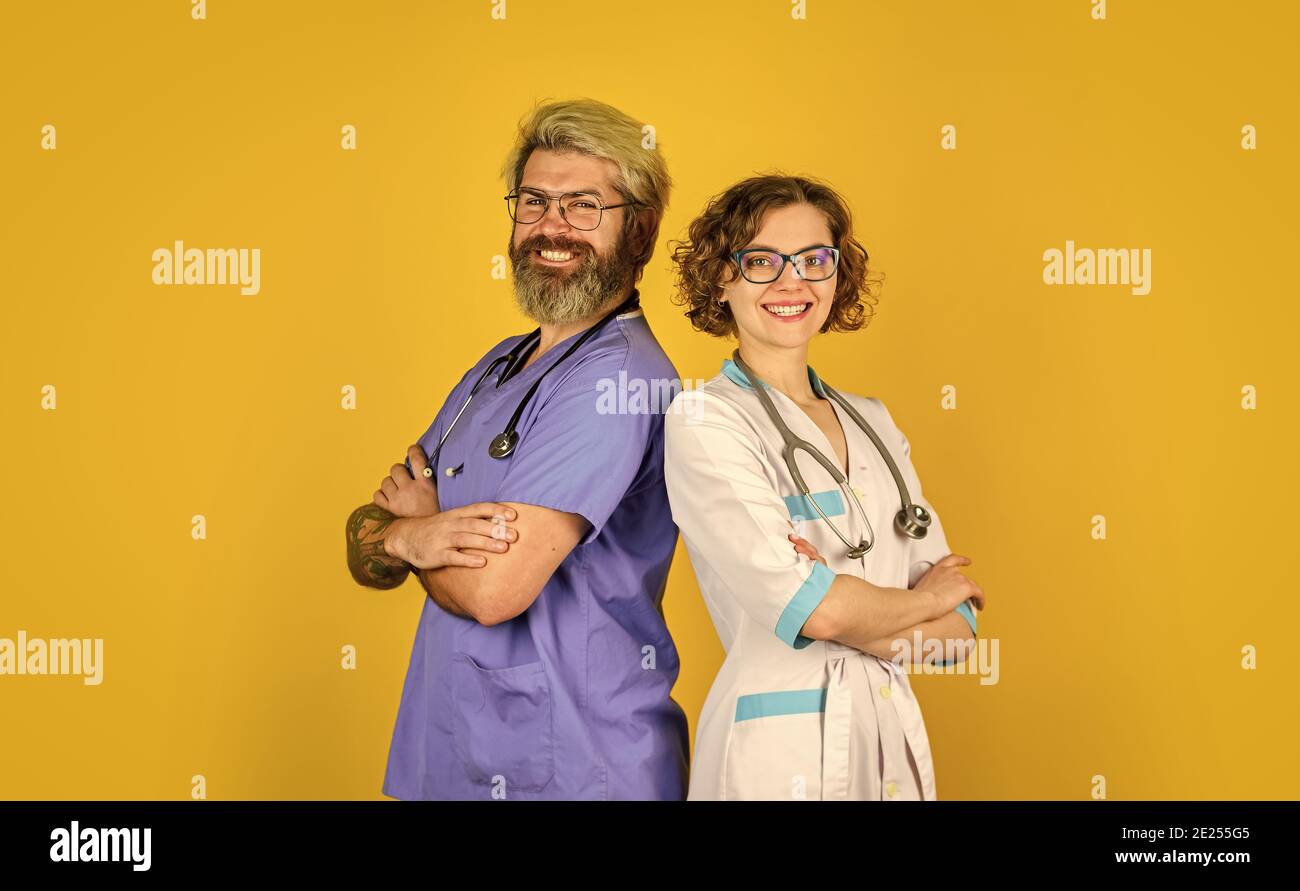 Erfolgreiches Team von Ärzten. Menschen in Uniformen gelber Hintergrund. Medizinisches Personal. Vertrauen Sie unseren Mitarbeitern. Gesundheitswesen, Teamarbeit und Personalkonzept. Arzt und Krankenschwester. Stockfoto