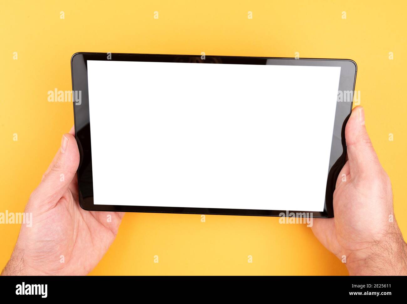 Nahaufnahme der Hände, die einen Tablet-Computer mit Kopierplatz halten Auf dem Bildschirm vor orangefarbenem Hintergrund Stockfoto