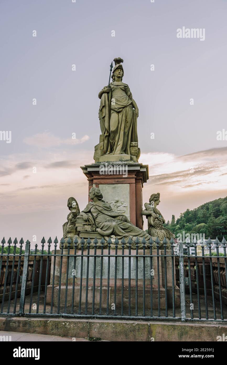 Heidelberg, Deutschland - 1. Aug 2020: Skulptur der römischen Göttin Minerva auf einer alten Brücke nach Sonnenuntergang Stockfoto