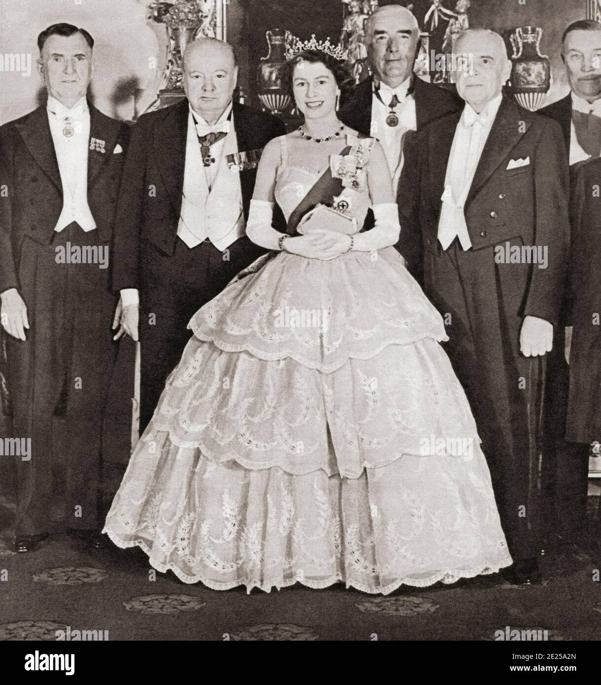 EDITORIAL NUR Queen Elizabeth II unterhält die Premierminister des Commonwealth im Buckingham Palace im Jahr 1952. Von links nach rechts, Mr. S.G. Holland (Neuseeland), Winston Chuchill (Großbritannien), Robert Menzies (Australien) und St. Laurent (Kanada). Aus dem Königin-Elisabeth-Krönungsbuch, veröffentlicht 1953. Stockfoto
