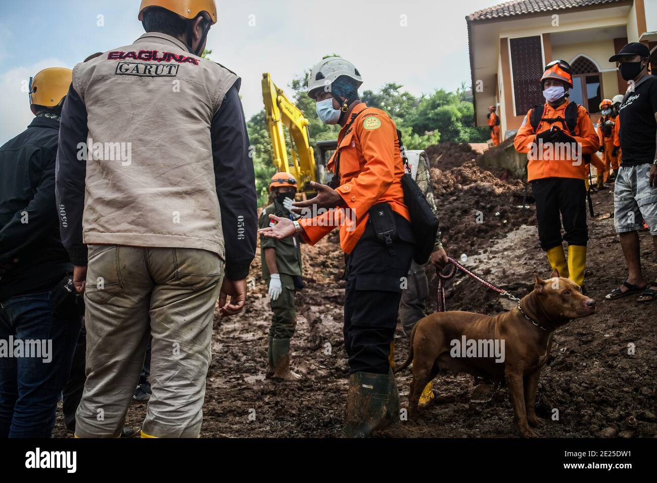 Sumedang, Indonesien. Januar 2021. Ein Mann gibt dem Rettungsteam im Dorf Cihanjuang während der Durchsuchung Anweisungen. Jüngste Berichte über Erdrutsch, ausgelöst durch heftigen Regen am Sonntag, deuten darauf hin, dass 16 Menschen starben und 23 Menschen immer noch vermisst werden. Kredit: SOPA Images Limited/Alamy Live Nachrichten Stockfoto