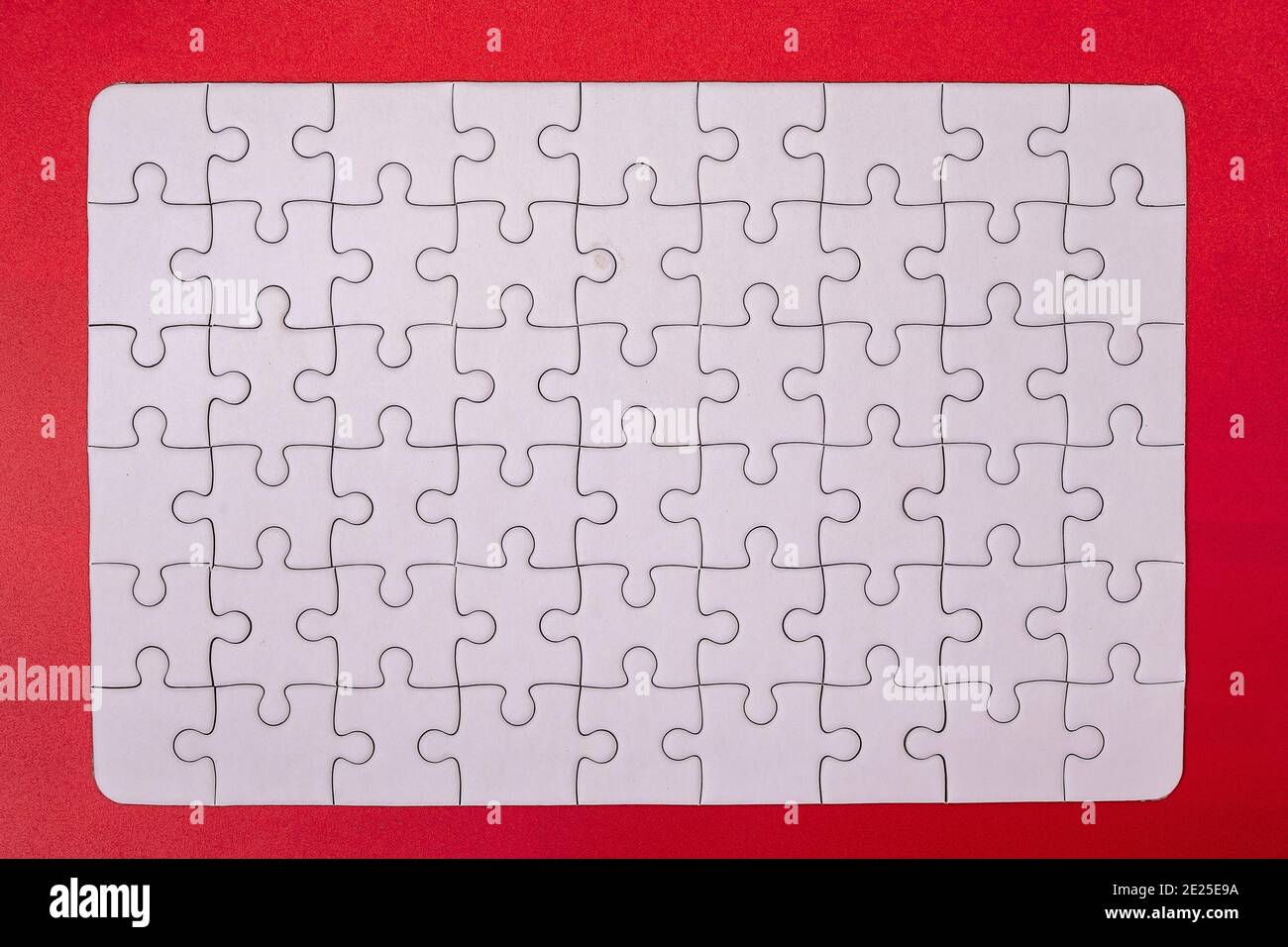 Leeres weißes Papier Puzzle Erfolg Mosaik Lösung mockup für Bedruckbare Puzzle Stücke Gitter Design-Vorlage isolieren auf rotem Hintergrund Stockfoto