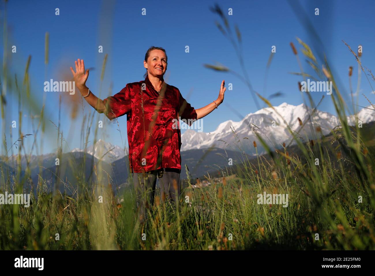 Frau, die Qi Gong oder Tai Chi Übungen vor dem Mont Blanc Massiv praktiziert. Französische Alpen. Frankreich. Stockfoto