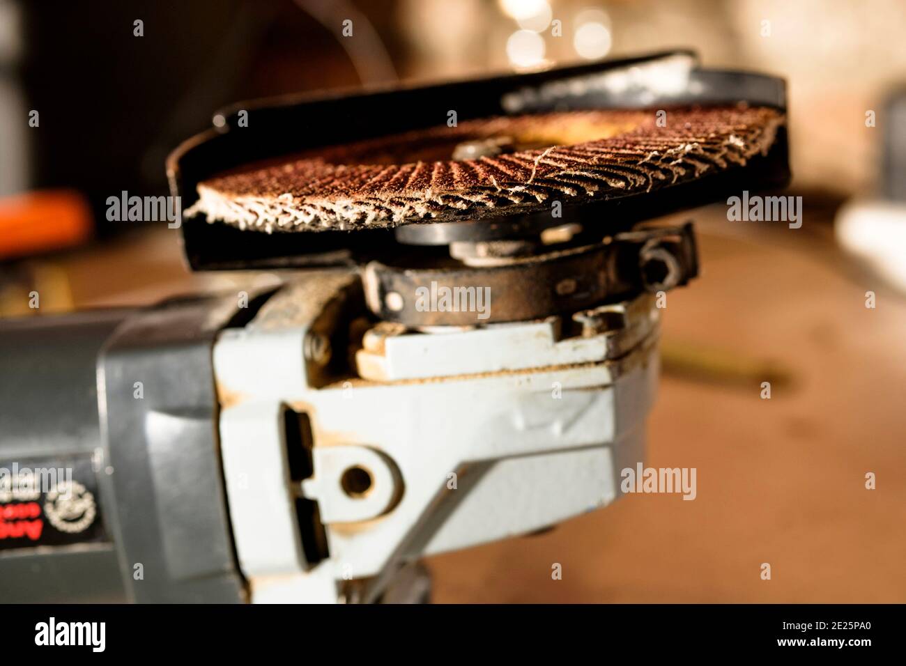 Eine flapige Schleifscheibe, die auf einem Handwinkelsegger montiert ist. Stockfoto