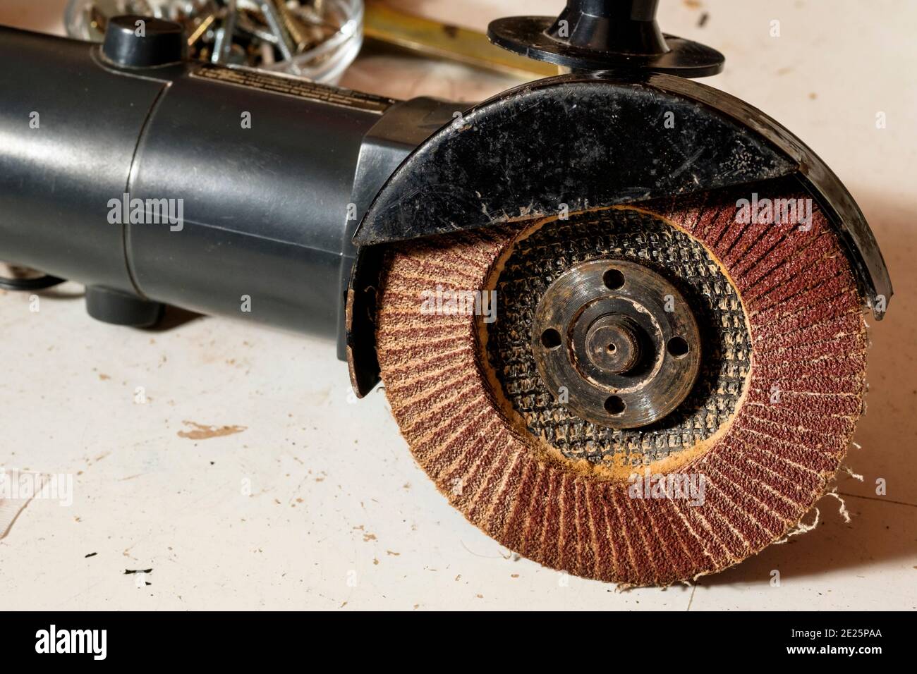 Eine flapige Schleifscheibe, die auf einem Handwinkelsegger montiert ist. Stockfoto