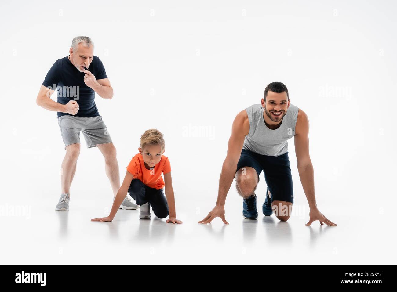 Reifer Mann pfeift in der Nähe von Vater und Sohn im Tiefstand Position auf Weiß Stockfoto