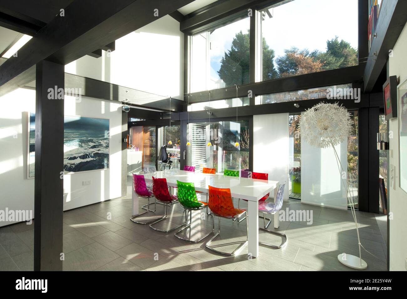 Essbereich im huf haus mit farbenfrohen Stühlen im Sonnenlicht Stockfoto