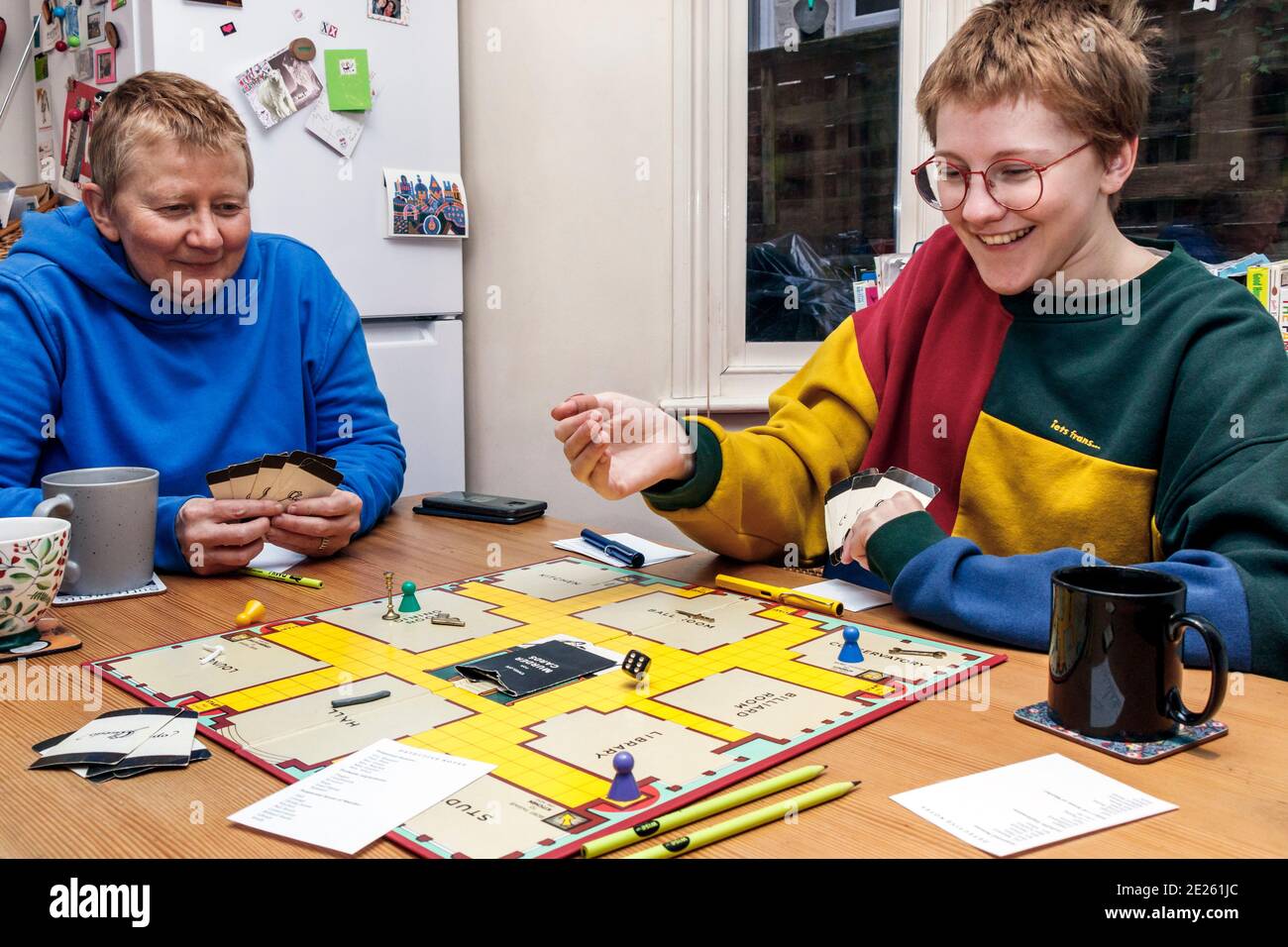 Mutter und Tochter spielen ein Familienspiel von Cluedo während der 3. Coronavirus Pandemie Aussperrung, London, Großbritannien Stockfoto