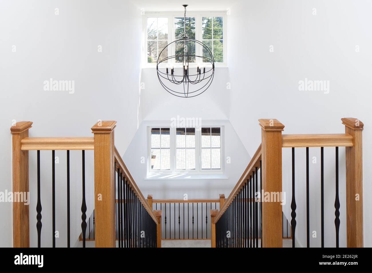 Symmetrisches Holz und schmiedeeisernes Treppenhaus Atrium mit Globe Laterne Im neuen Haus Stockfoto