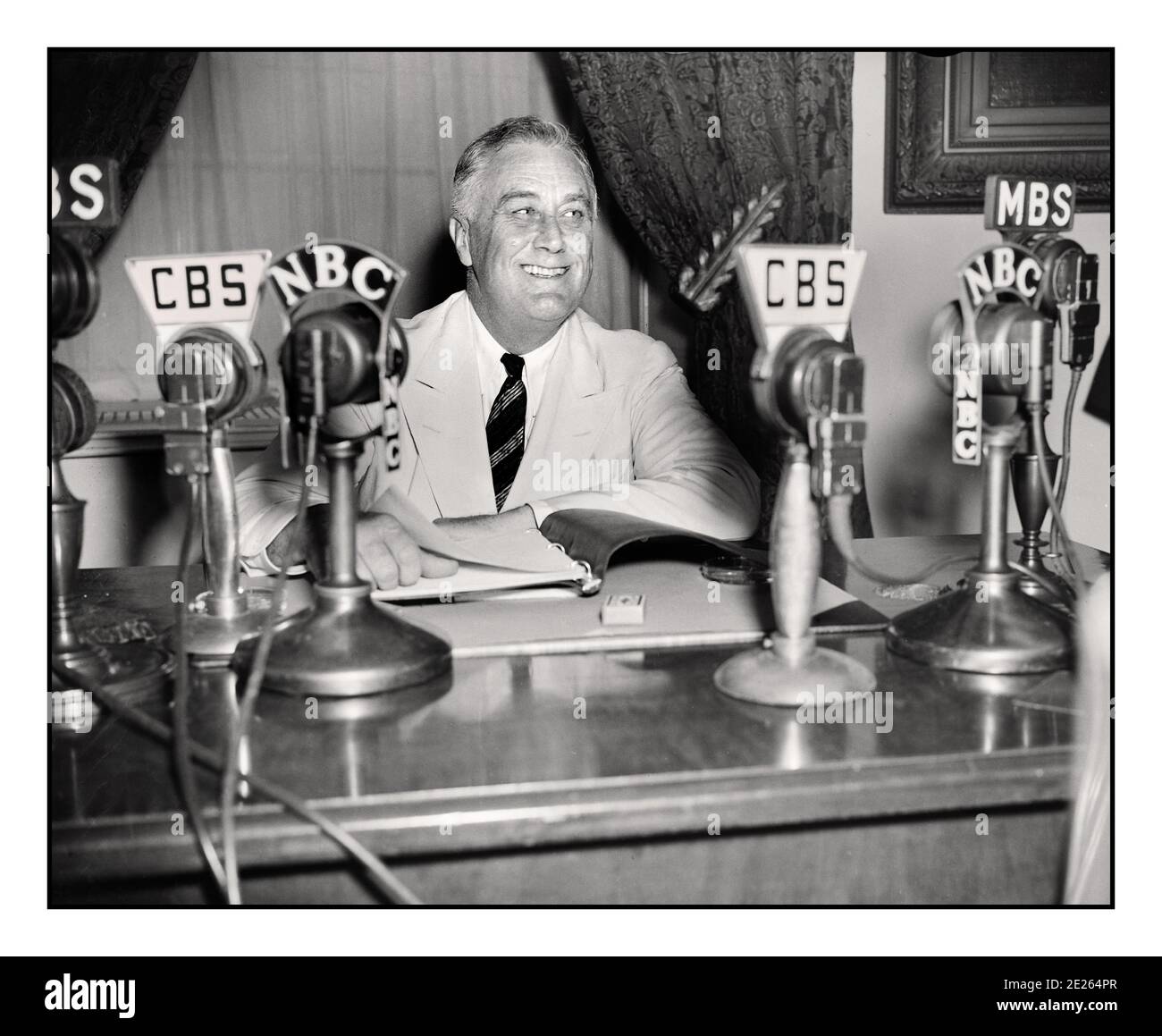 PRÄSIDENT ROOSEVELT 1930er FDR Franklin D. Roosevelt, der eine Radiosendung ("Kamingespräch") September 1934 gab. Auf seinem Schreibtisch CBS & NBC Netzwerk Broadcast Mikrofone. Franklin Delano Roosevelt Sr., oft mit seinen Initialen FDR bezeichnet, war ein amerikanischer Staatsmann und politischer Führer, der als 32. Präsident der Vereinigten Staaten von 1933 bis zu seinem Tod im Jahr 1945 diente. Stockfoto