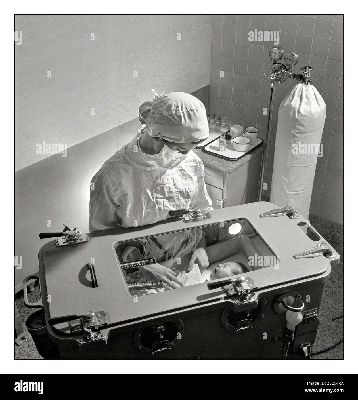 1940er INKUBATOR Krankenhaus vorzeitige Baby-Einheit November 1942. New York. Pflege von früh geborenen Babys komplizierte Verfahren, die von einer studentischen Krankenschwester gelernt werden müssen. Fütterung, Baden etc. Werden im Inkubator durchgeführt, in dem Temperatur, Feuchtigkeit und Sauerstoff mit Sauerstoffversorgung im Hintergrund sorgfältig geregelt werden müssen.“ Eine neonatale Intensivstation, auch als Intensivstation bekannt, ist eine Intensivstation, die sich auf die Betreuung von kranken oder frühgeborenen Neugeborenen spezialisiert hat. Stockfoto